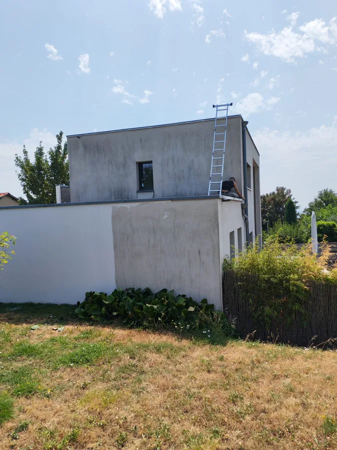 Façade en enduit noircie par les coulures avant ravalement — maison contemporaine à toit plat